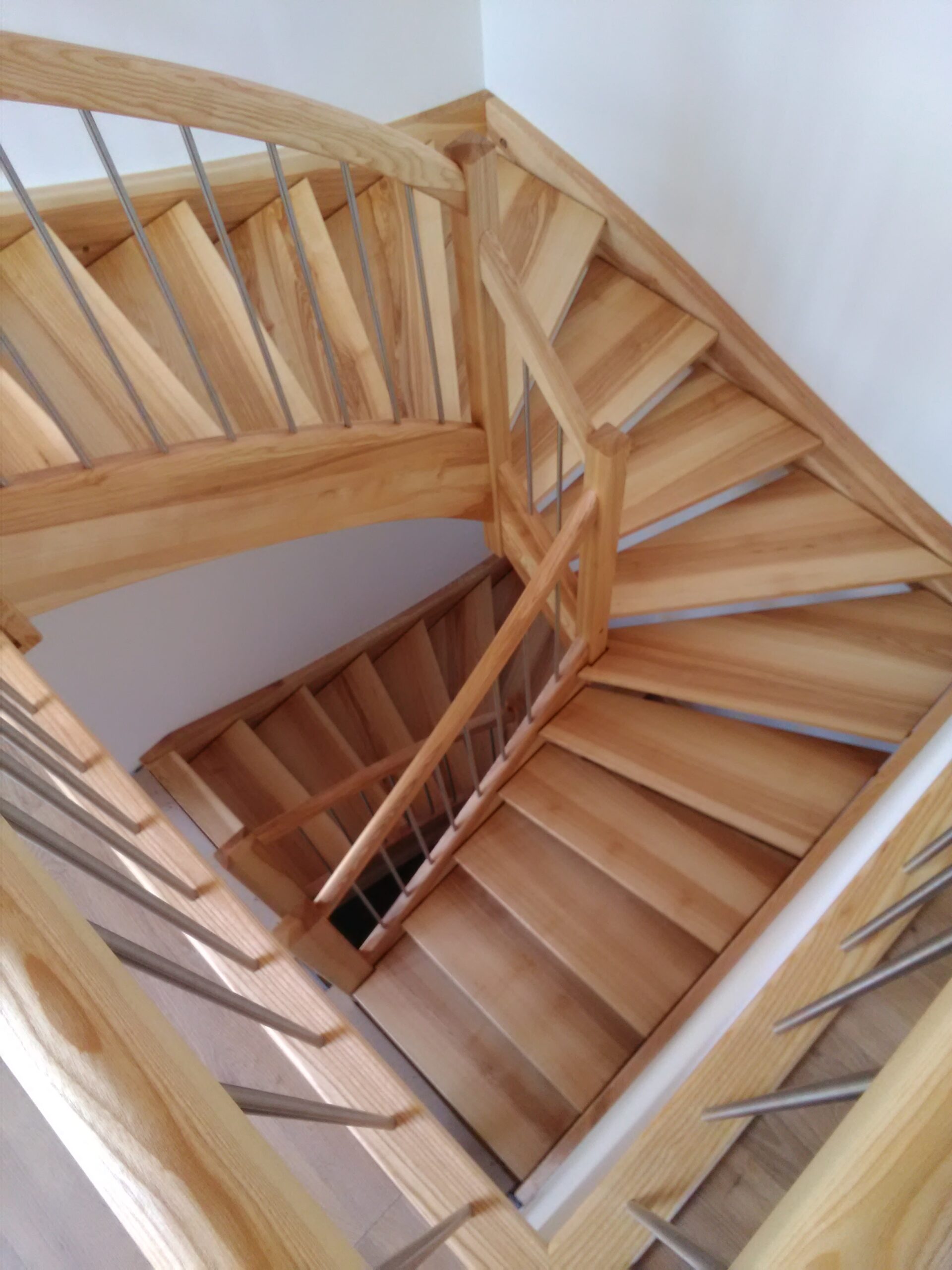 Gewendelte Holztreppe mit Edelstahlgeländer